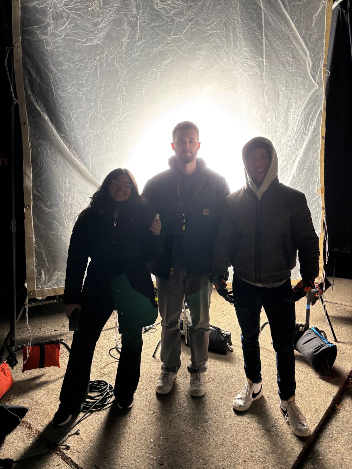 Film crew silhouetted against a backlit diffusion frame