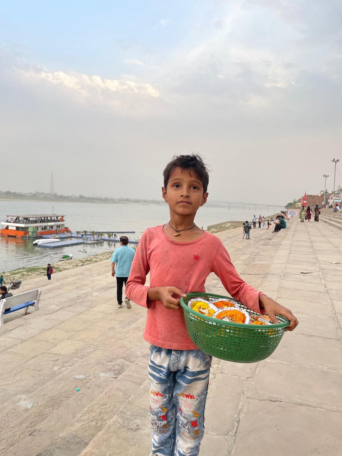 Child with a basket of marigolds on the ghats