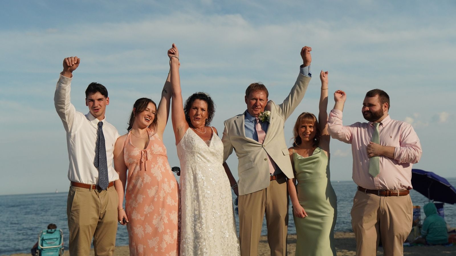 Wedding party cheering by the water
